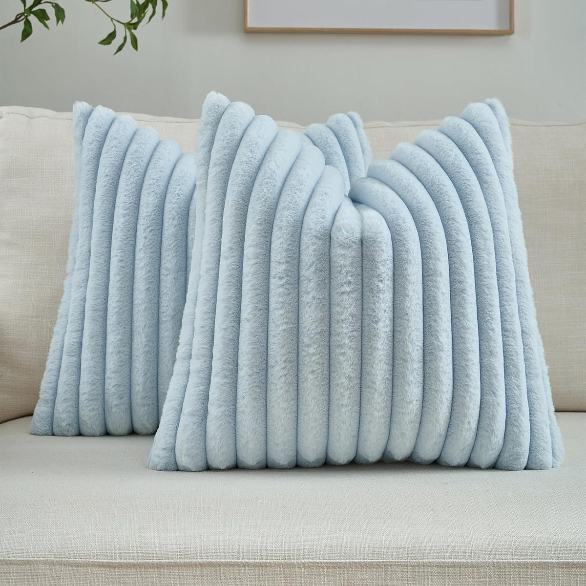 Verdelisse faux fur throw pillow covers in Light Blue, a pair on a light grey sofa