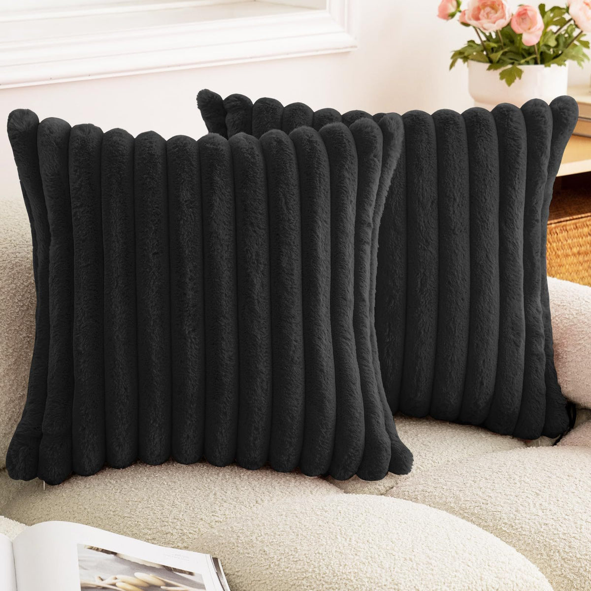 Verdelisse faux fur throw pillow covers in Black, a pair on a boucle sofa