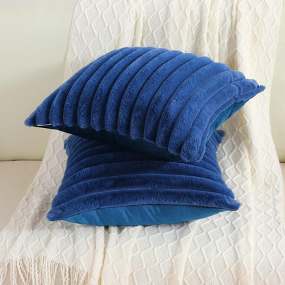 Verdelisse faux fur throw pillow covers in Royal Blue, two covers stacked on a white knit throw