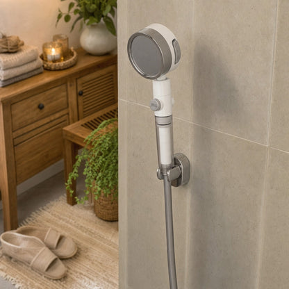 Verdelisse Filtered Showerhead in White, in a wall holder in a tiled shower