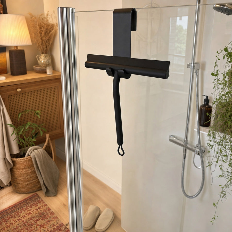 Verdelisse Silicone Shower Squeegee in Black, hanging on its hook over a glass shower door