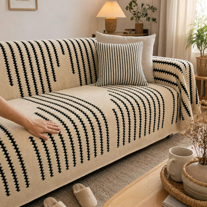 Hand smoothing the Verdelisse Stripes Sofa Cover over the sofa seat