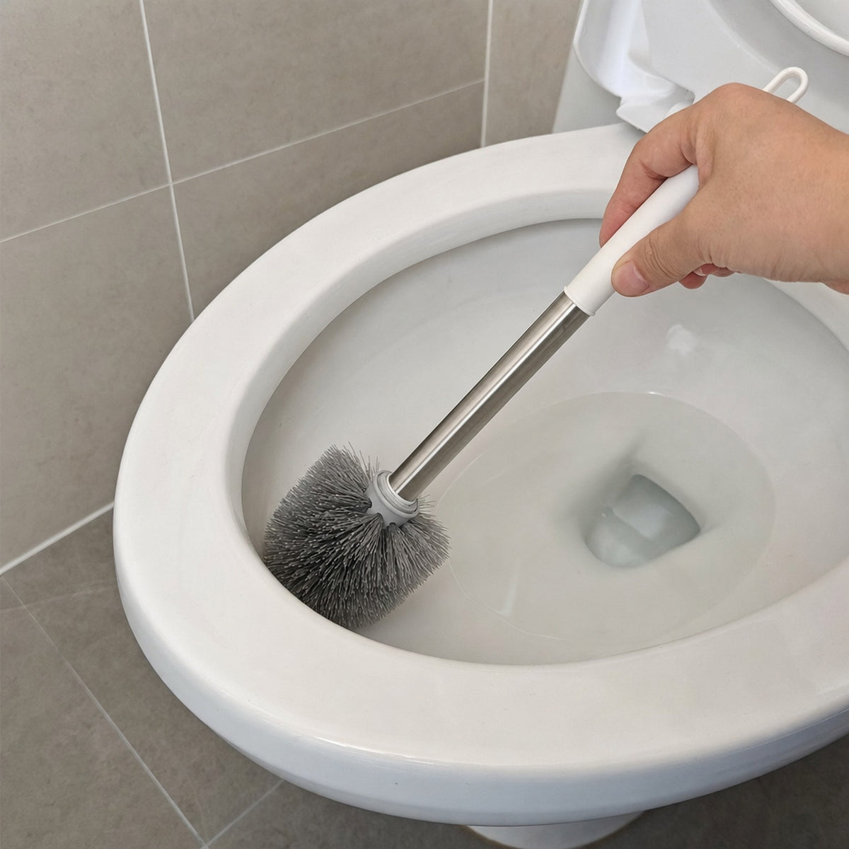 Hand cleaning under the toilet rim with the Verdelisse toilet brush with flexible grey head and aluminium handle