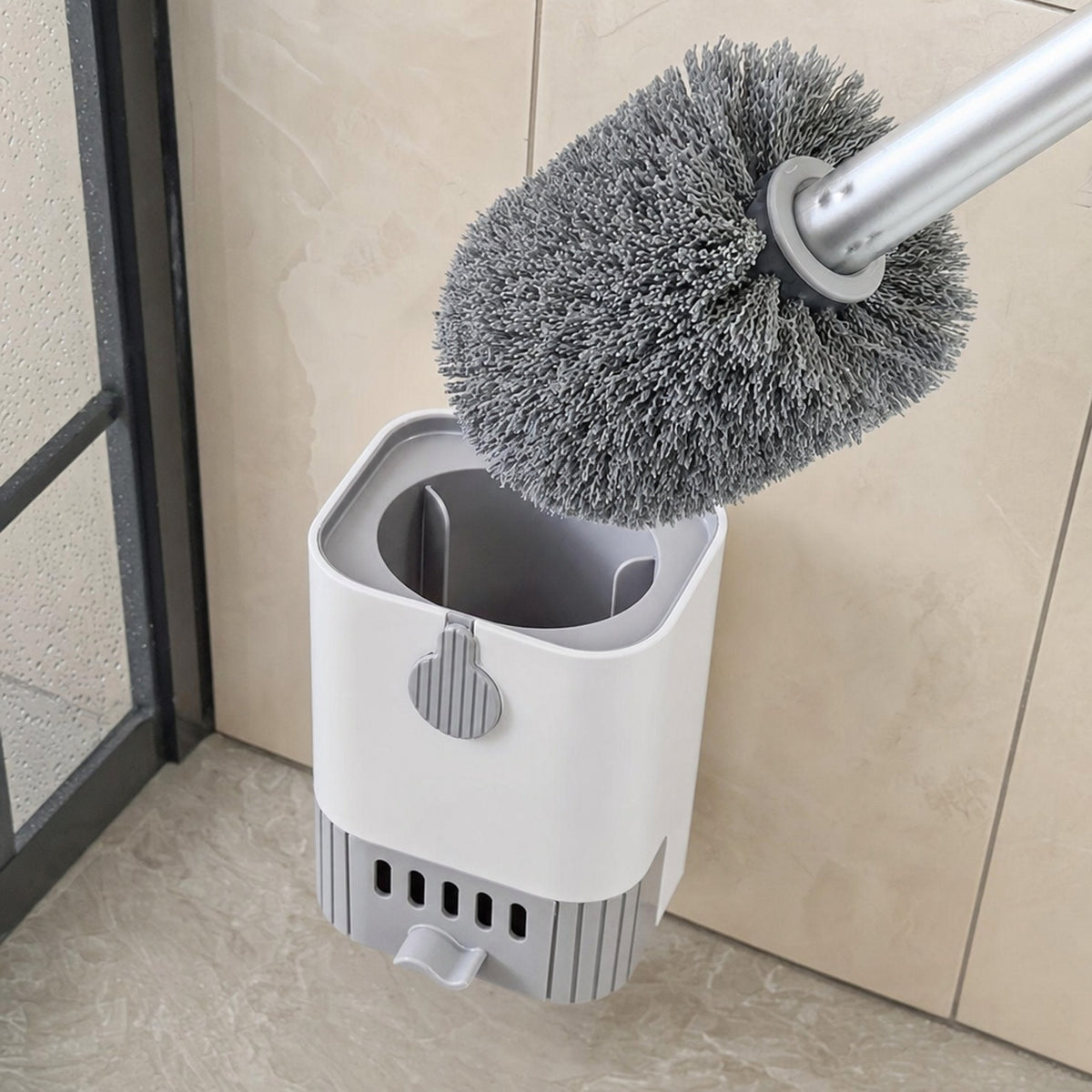 Close-up of the Verdelisse toilet brush lifted from its white holder, showing the flexible grey brush head