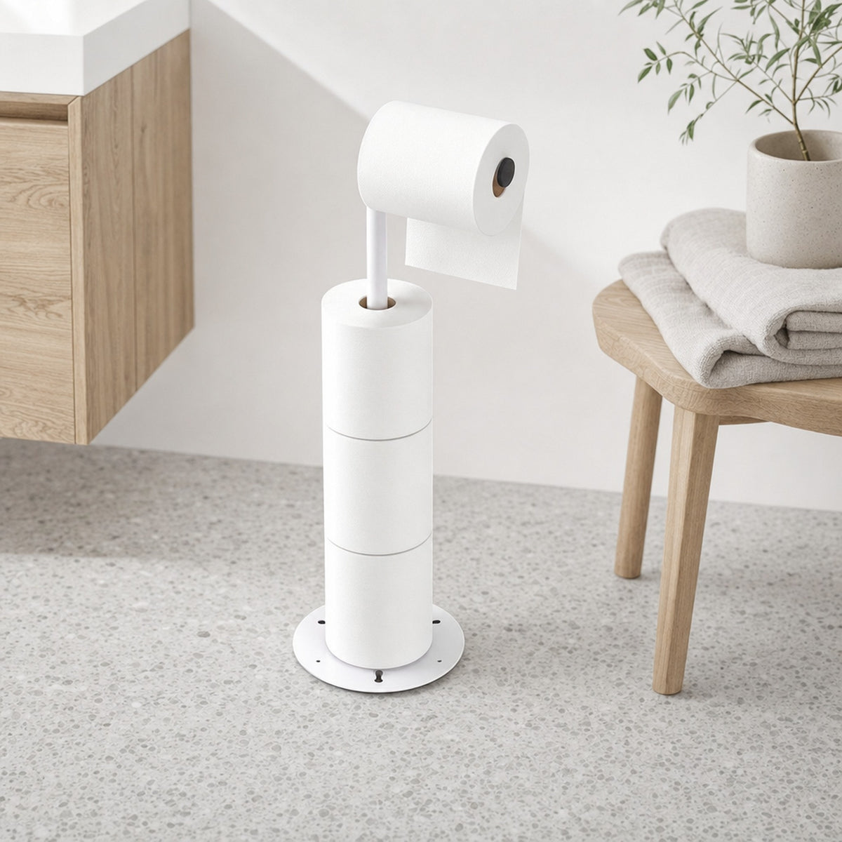 Verdelisse freestanding toilet paper holder in matte white in a bright Scandinavian bathroom with a wooden stool